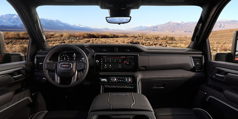 The Interior Dashboard and Steering Wheel of the GMC Sierra Truck with a Desert View Through the Windshield