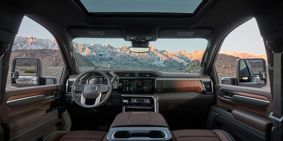 The Interior Dashboard and Steering Wheel of the GMC Sierra 1500 Truck with a Mountain View Through the Windshield