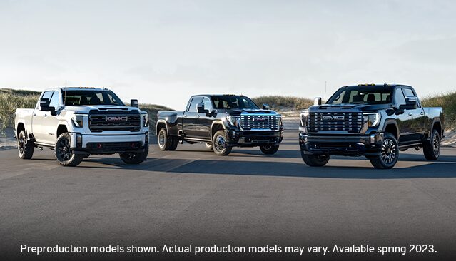 Three GMC Sierra HD Trucks, a White AT4X a Dark Gray Denali and a Black Denali Ultimate, Parked Side-by-Side