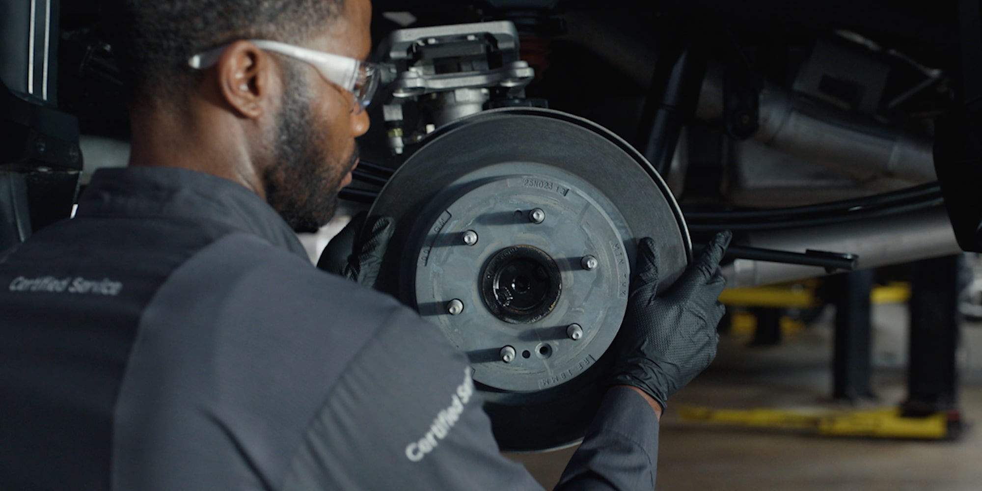 GMC Certified Service Technician Installing Brake Rotor on a Vehicle