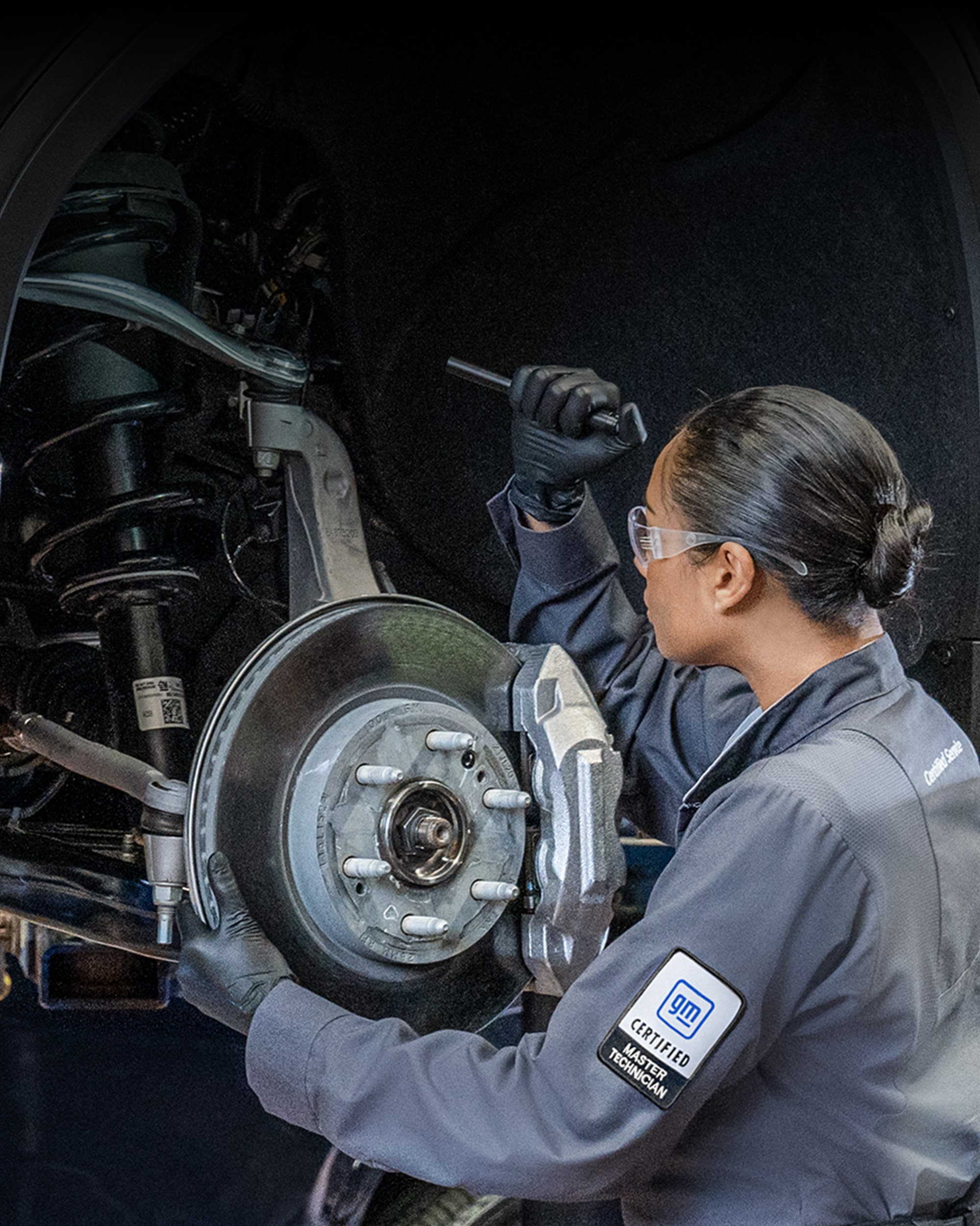 A Woman and Man Service Technician in a Service Garage Working on GMC Vehicles.