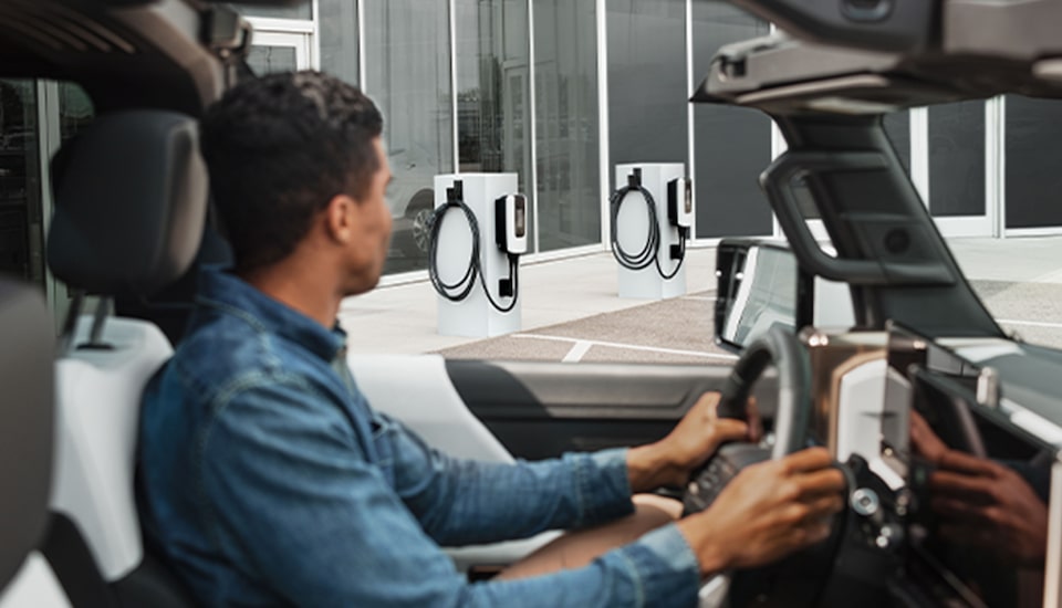 A GMC EV Pulling Up to Charging Station