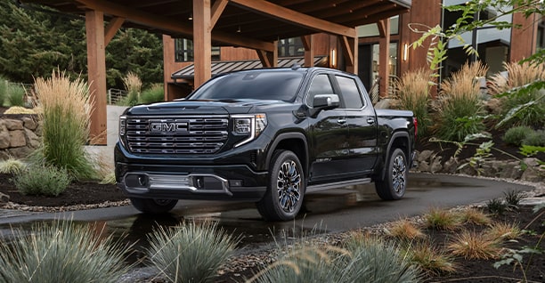 A Black GMC Truck Parked Outside a Large Home