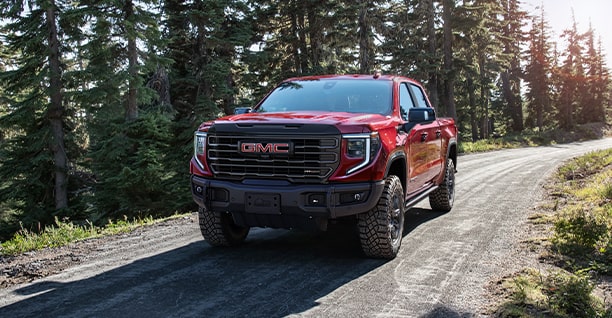 A Red GMC Truck Driving Down a Rural Road
