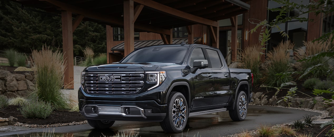 A Black GMC Truck Parked Outside a Large Home