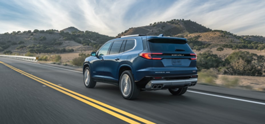 Rear View of a GMC SUV Driving Down a Highway