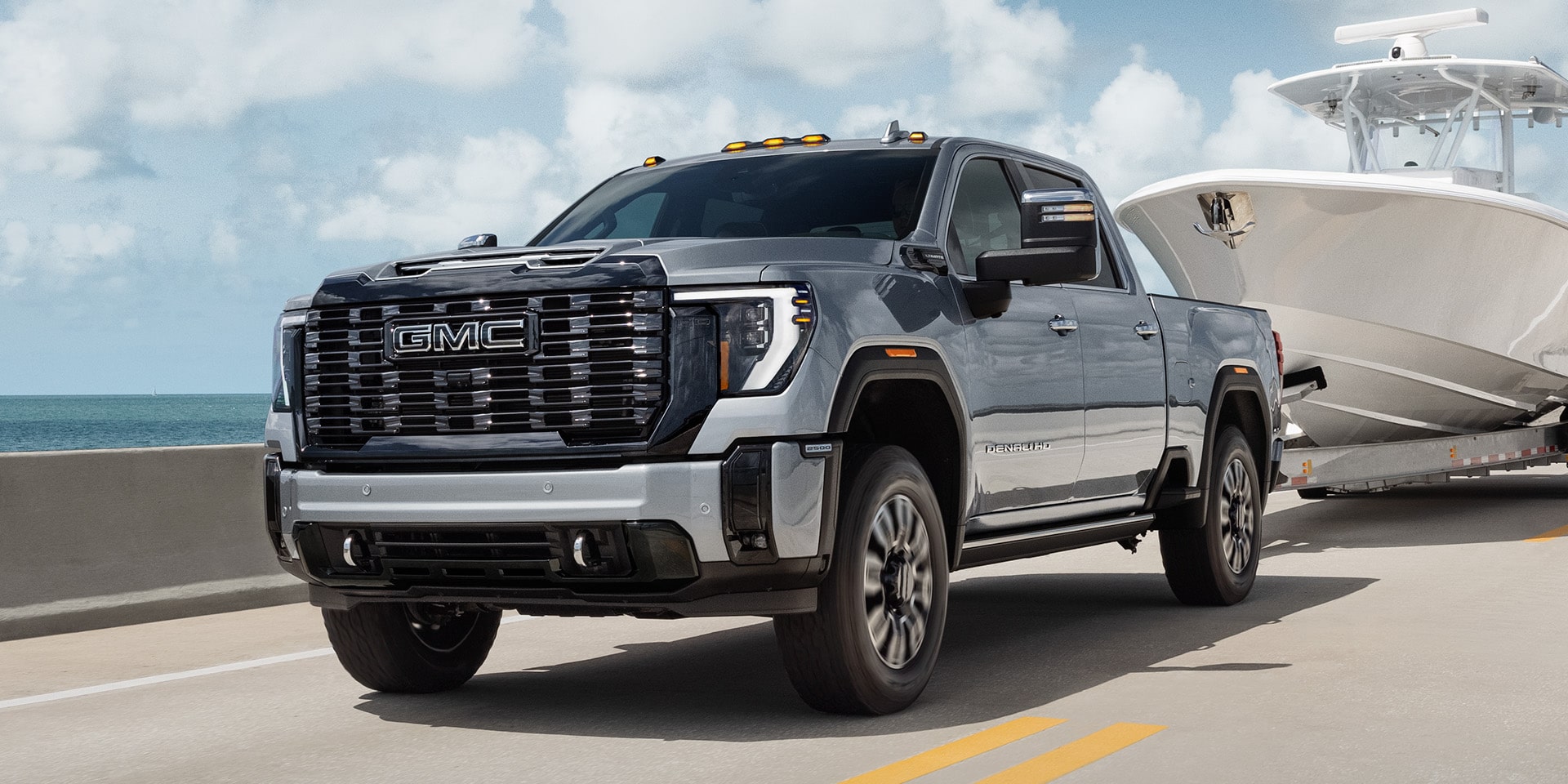 Front Three-Quarters View of the GMC Sierra HD Denali Ultimate Towing a Boat
