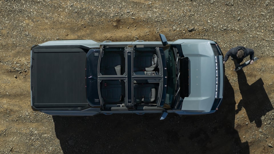 Birdseye View of the Transparent Sky Panels Opened on the 2025 Hummer EV While a Person is About to Load Panel in Front Trunk
