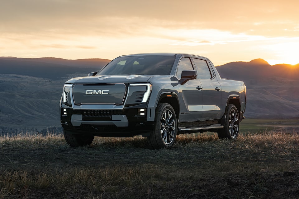 Three-Quarters View of a Parked GMC Sierra EV under a Clear Blue Sky