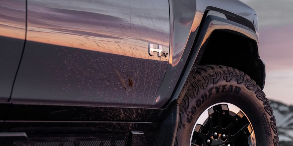 Low Angle Side View of a Front Tire of GMC Hummer EV SUV under an Evening Sky
