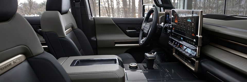 Side Interior View of a GMC Hummer EV SUV Surrounded by Trees