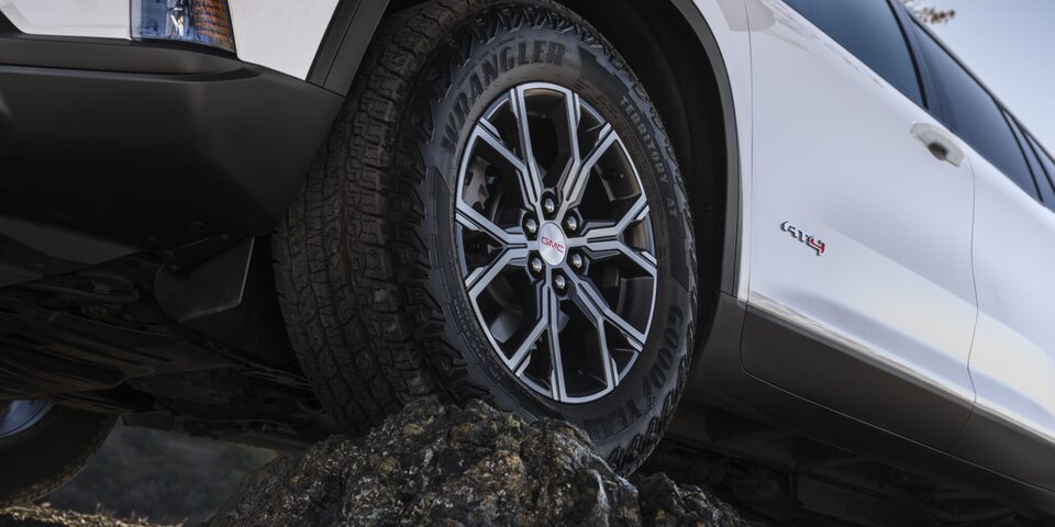 Close-up of the GMC Acadia AT4 Mid-Size Off-Road SUV Driving Over Rough Terrain