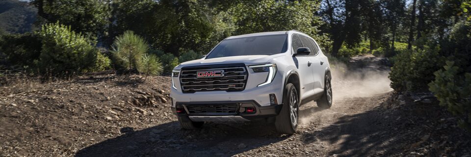 Front Three-Quarter View of the GMC Acadia AT4 Mid-Size SUV Driving Off-Road