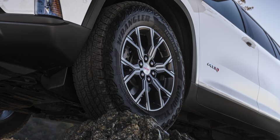 Close-up View of the GMC Acadia AT4 Mid-Size Off-Road SUV Driving Over Rough Terrain