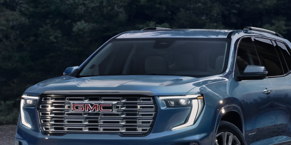 The GMC Acadia Denali Luxury SUV Park in the Woods Next to a Beautiful Cabin