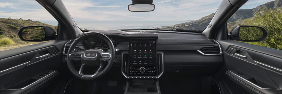 Drivers Side View of the GMC Acadia Steering Wheel and Infotainment System