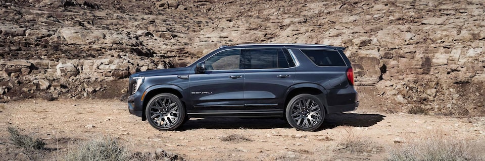 Profile View of the GMC Yukon Large SUV Parked in the Desert on Rough Terrain