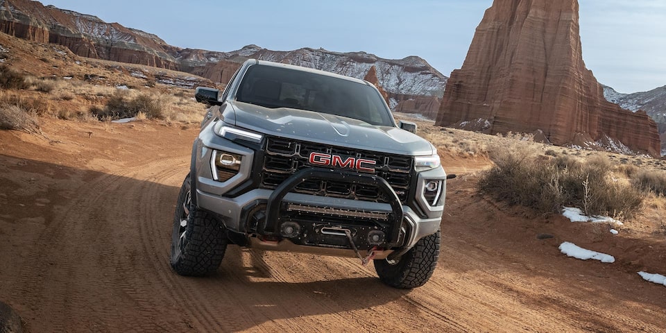 Front View of a 2025 GMC Canyon Driving Through a Desert Using Hill Descent Control