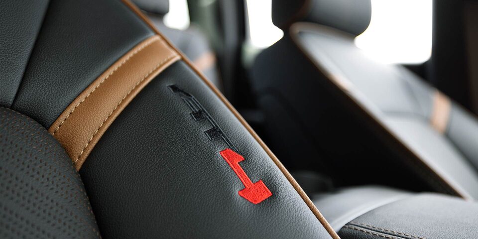 Close-up of the AT4 Stitching on a GMC Canyon's Brown and Black Leather Seat
