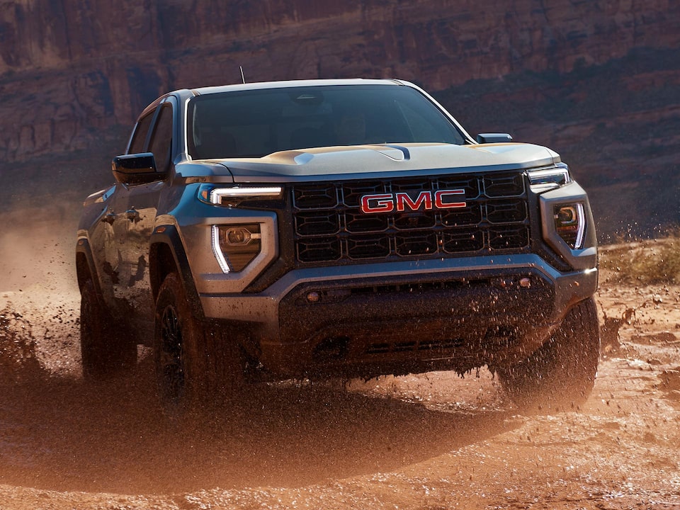 Three-quarters View of the 2025 GMC Canyon Truck Driving Through the Desert