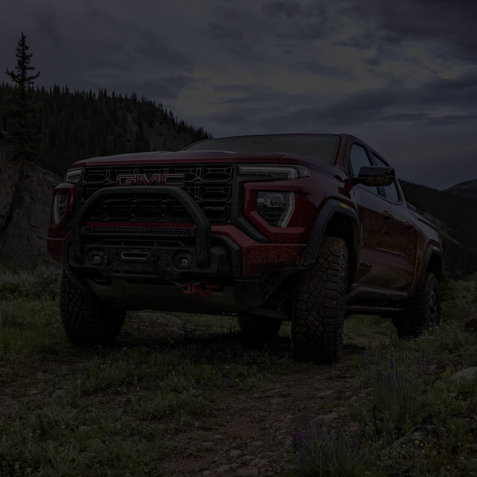 Three-quarters Low View of a Red 2025 GMC Canyon Parked in the Mountains