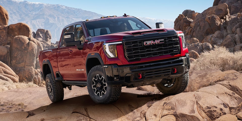Front Three-Quarters View of a 2025 GMC Sierra HD AT4X AEV Truck Parked on a Rocky Path