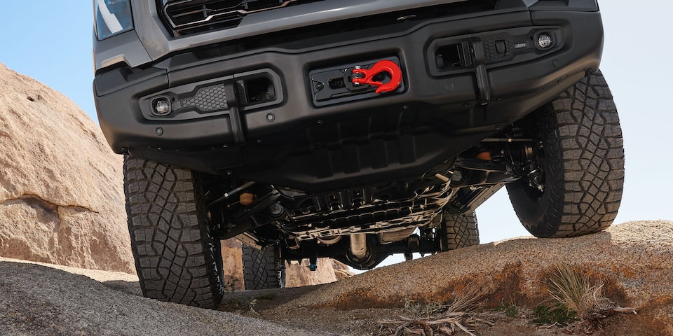 Close-up of the Front End on a 2025 GMC Sierra HD AT4 Truck Driving on Rocky Terrain