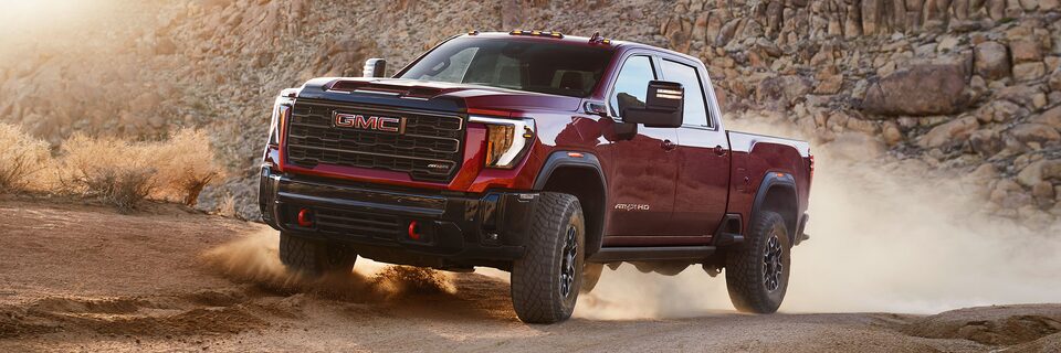 Wide Front Three-Quarters View of a 2025 GMC Sierra HD AT4 Truck Driving Through the Mountains