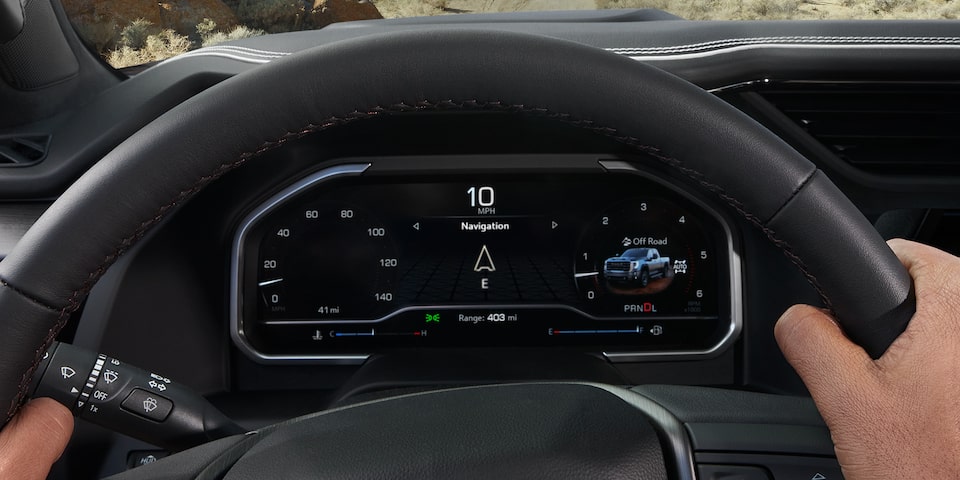 Close-up of the Digital Cockpit with the Driver's Hands on the Wheel in a 2025 GMC Sierra HD AT4 Truck