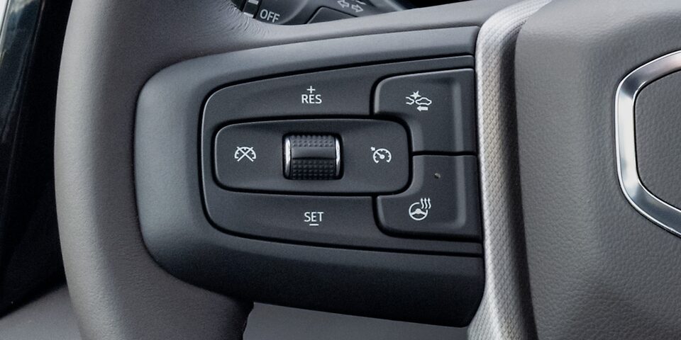 Close-up View of the Cruise Control Buttons on the Steering Wheel in a 2025 GMC Sierra HD Truck