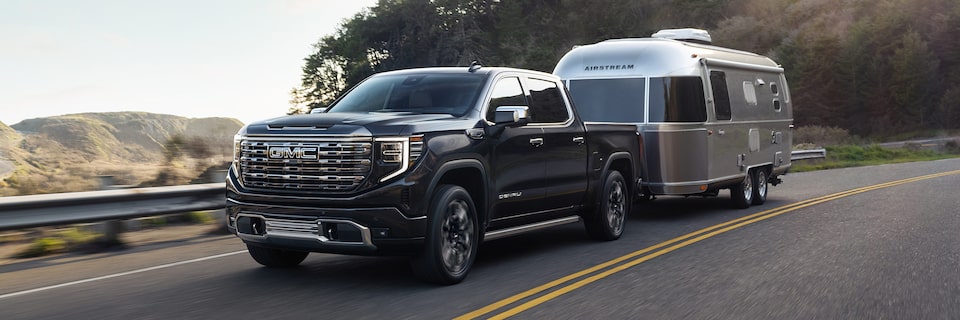 GMC Sierra Denali Towing an Airstream RV Down the Road