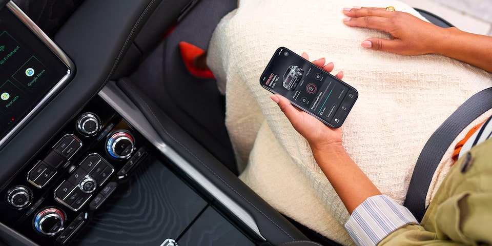 Over Head View of a Woman Sitting in the Passenger Seat of a GMC Vehicle Using her Smartphone