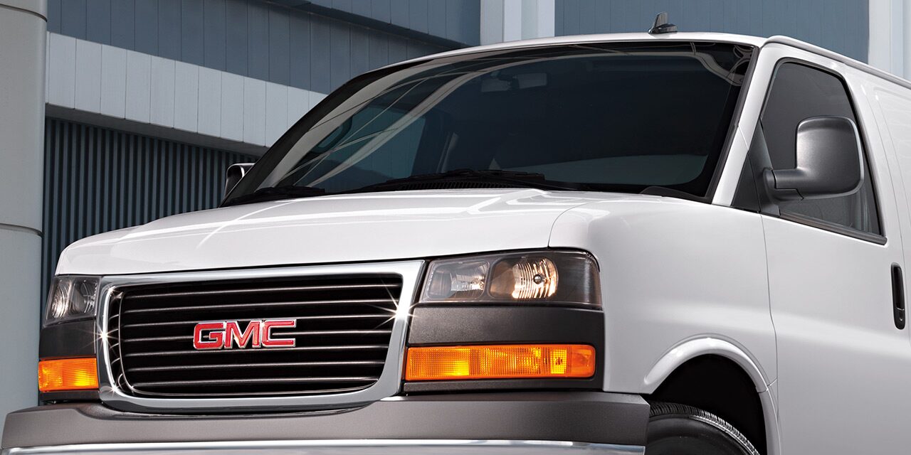 Close-Up Front View of a White 2026 GMC Savana Van, Focusing on the Grille and GMC Logo