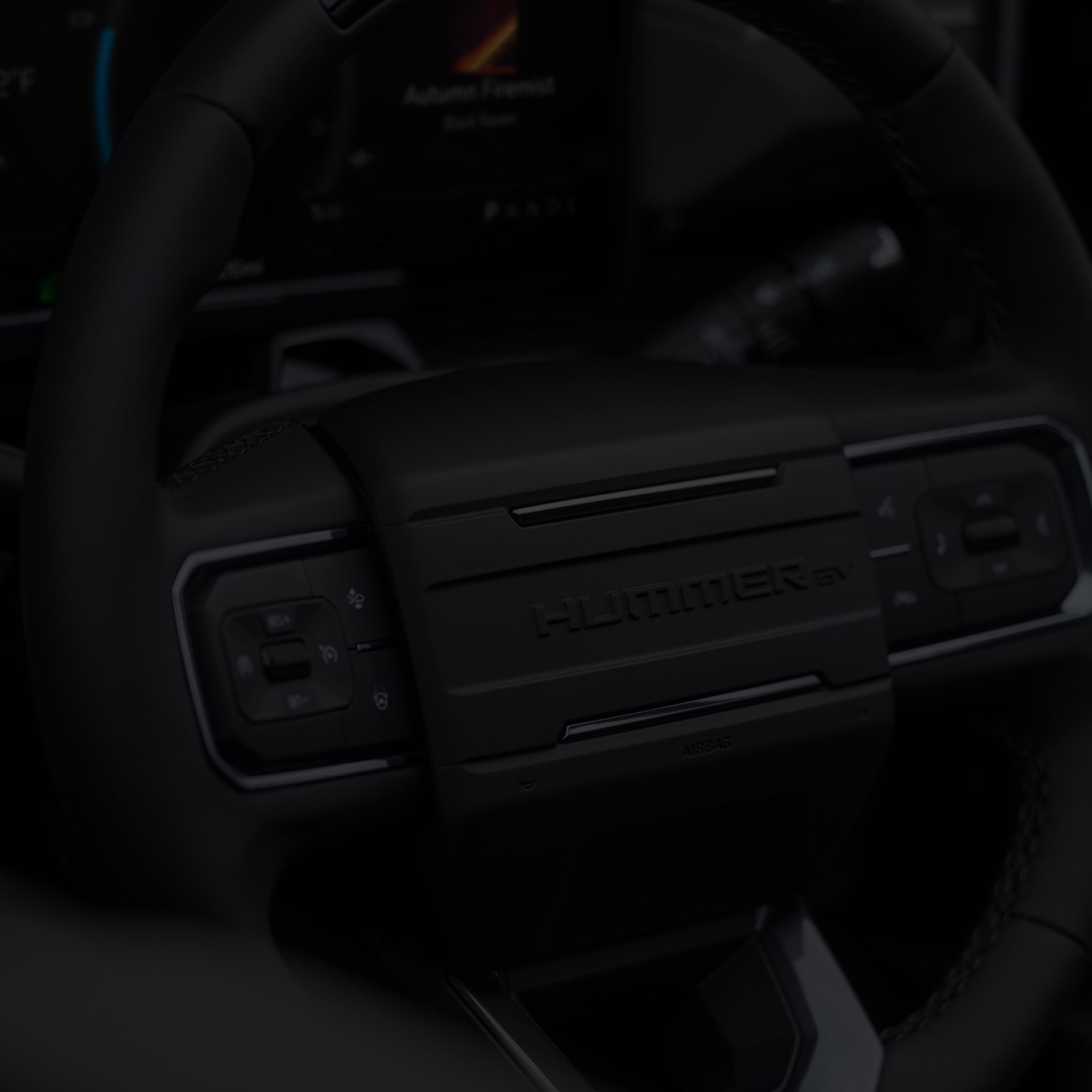 Close-up of the 2026 HUMMER EV Pickup Truck All-black Steering Wheel