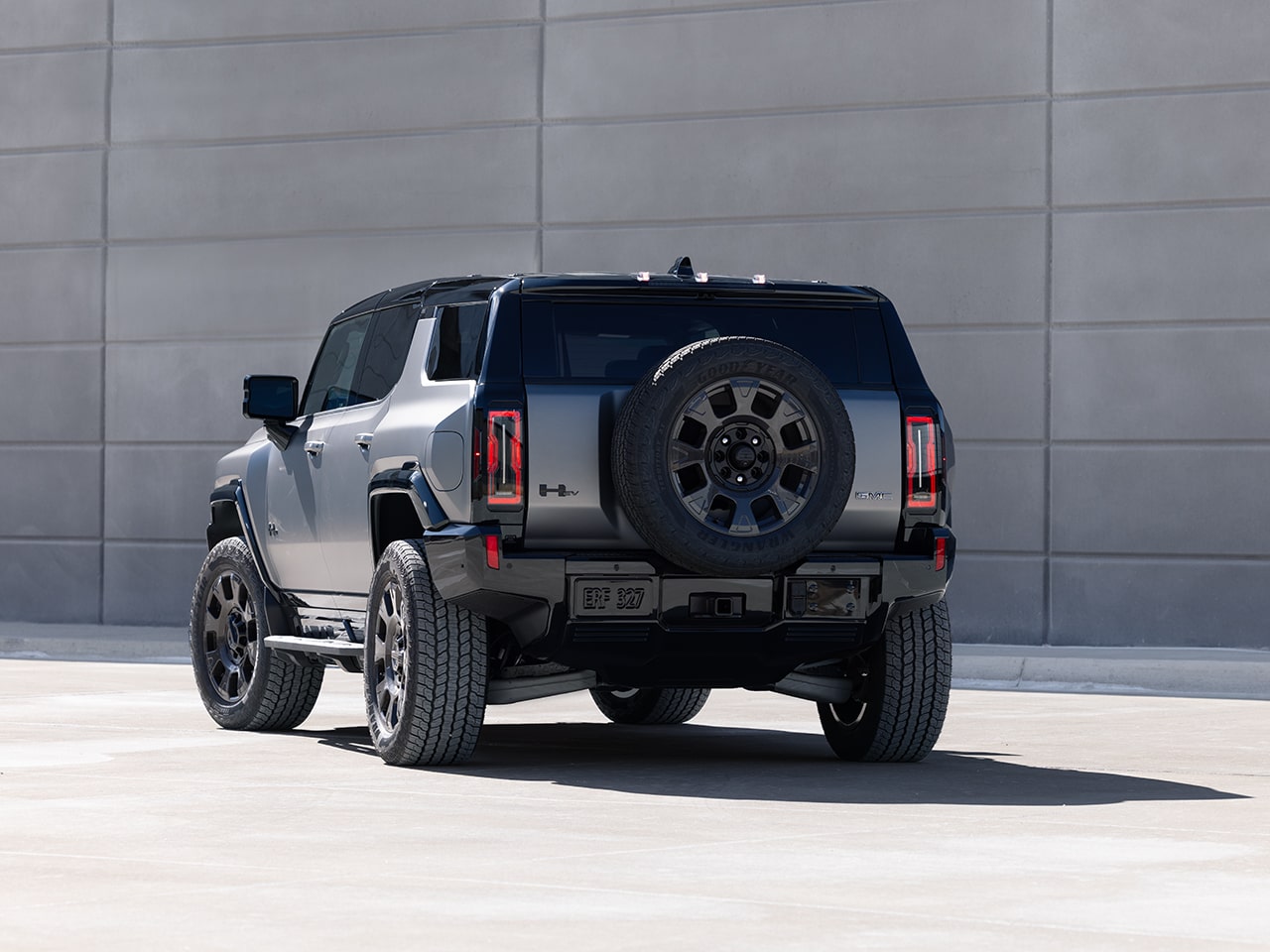 Rear End View of the 2026 GMC HUMMER EV SUV Parked by a Concrete Wall