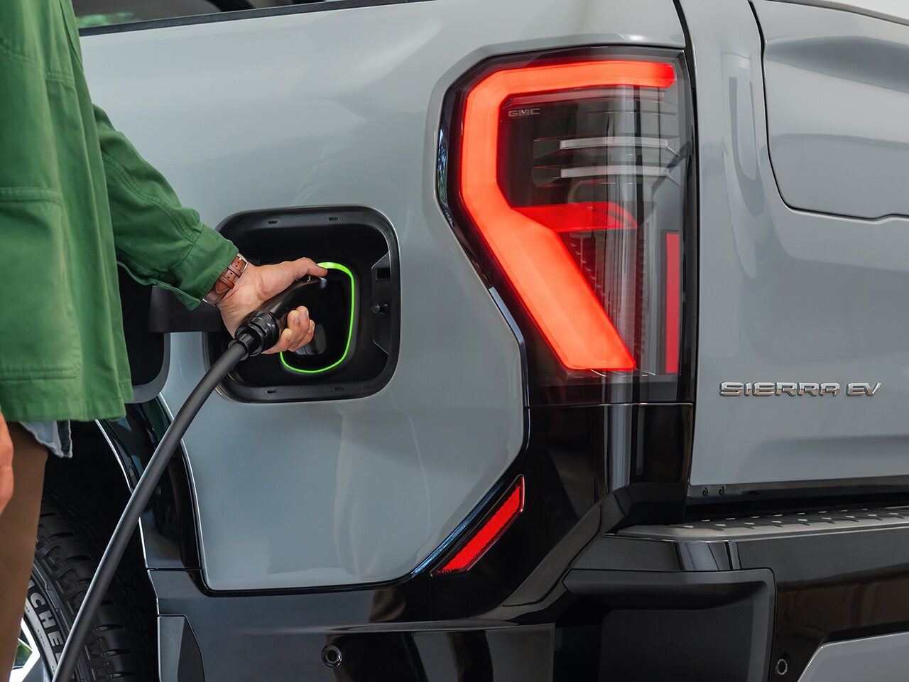 Close-Up of the Driver Charging Their 2026 GMC Sierra EV AT4