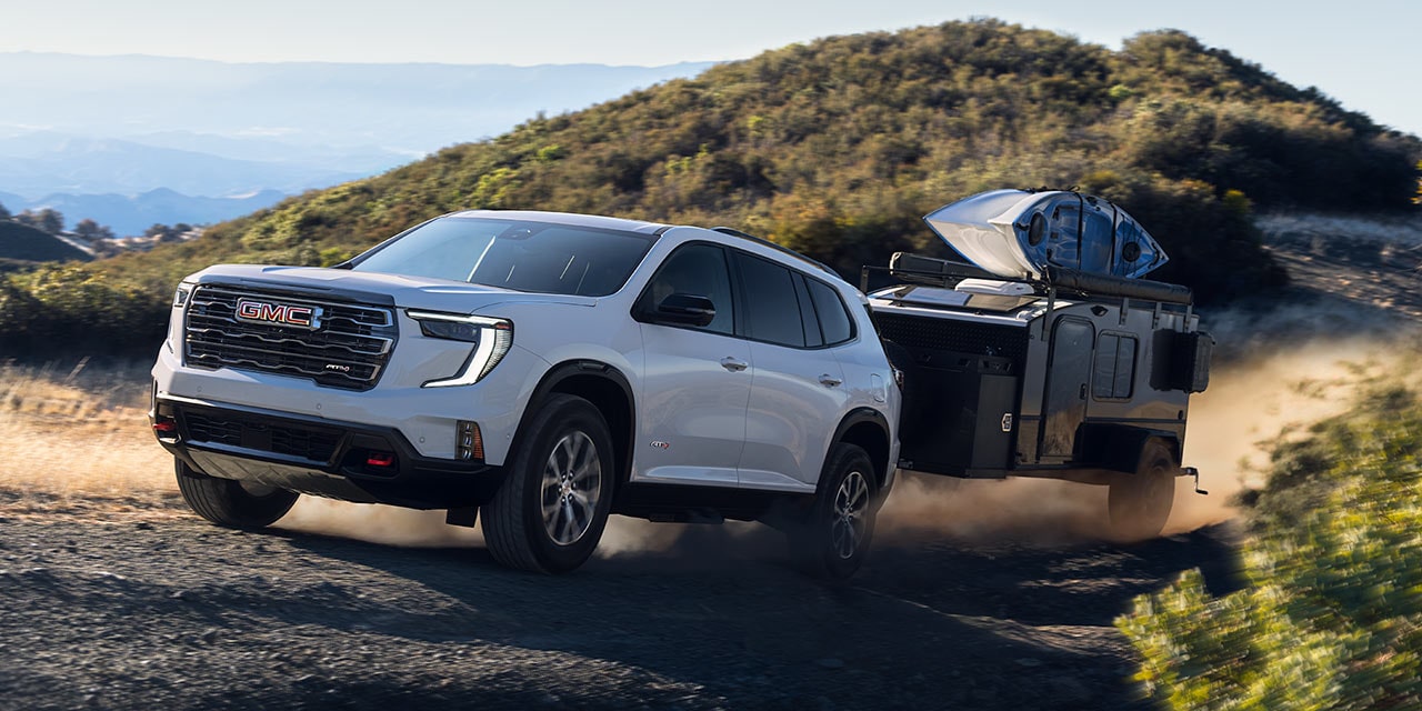 Exterior View of the 2026 GMC Acadia Mid-Size SUV Towing a Trailer