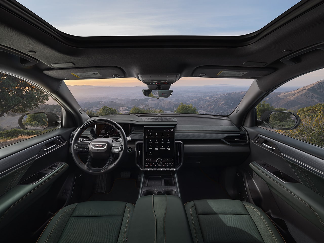 Interior Close-up View of the Steering Wheel and Infotainment System in the GMC Acadia Mid-Size SUV