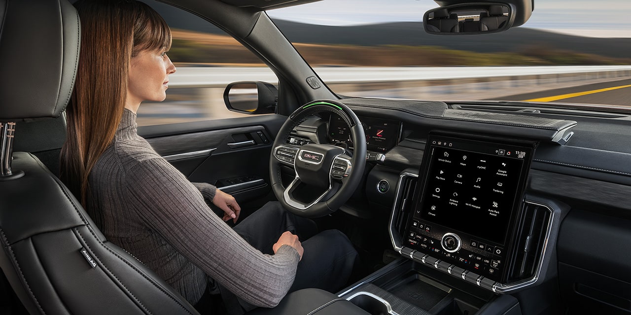 Profile View of a Woman Using Super Cruise Driver Assistance Technology in the 2026 GMC Acadia Mid-Size SUV