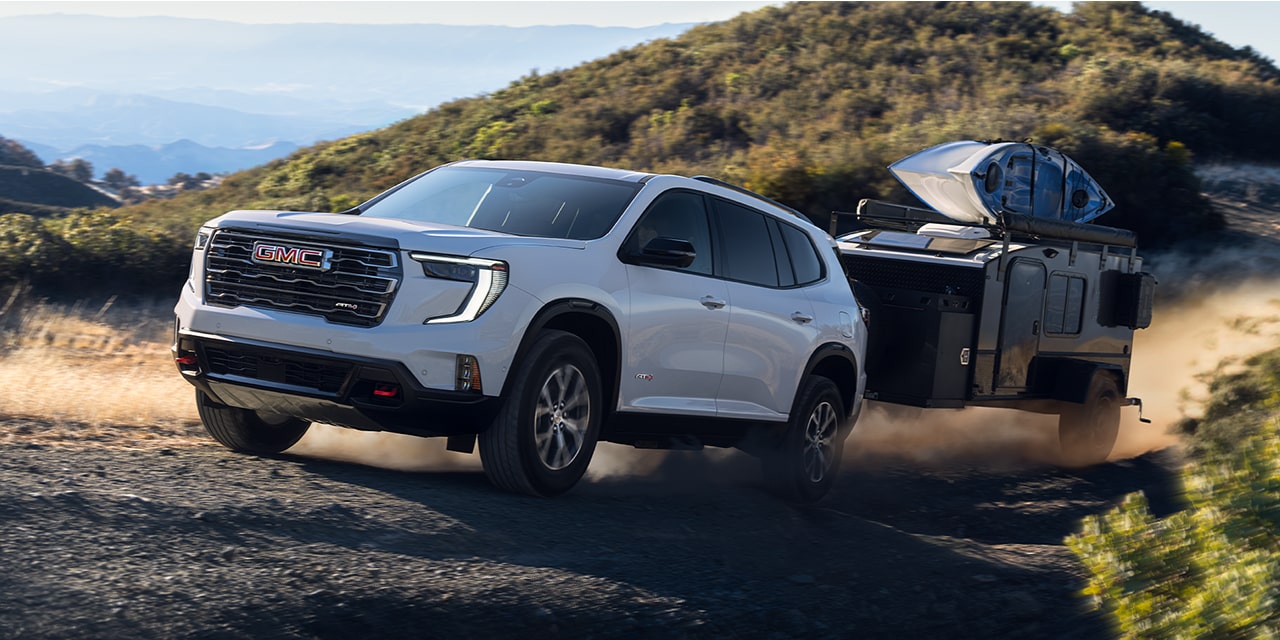 Exterior View of the 2026 GMC Acadia Mid-Size SUV Towing a Trailer