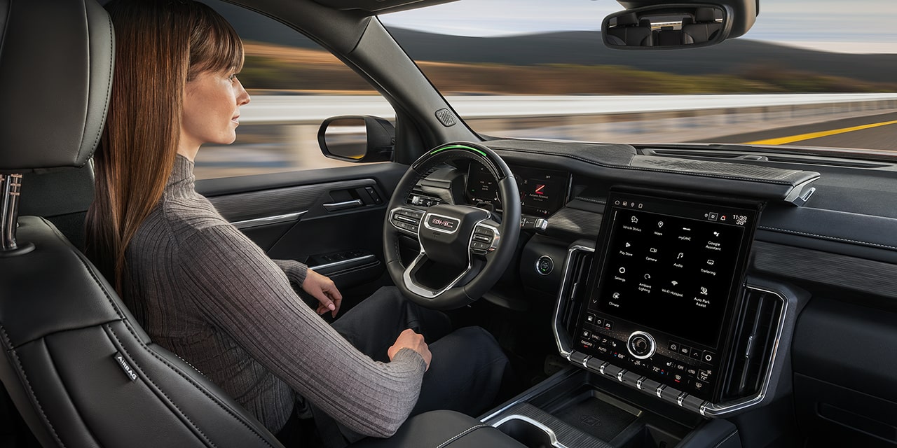 Profile View of a Woman Using Super Cruise Driver Assistance Technology in the 2026 GMC Acadia Mid-Size SUV