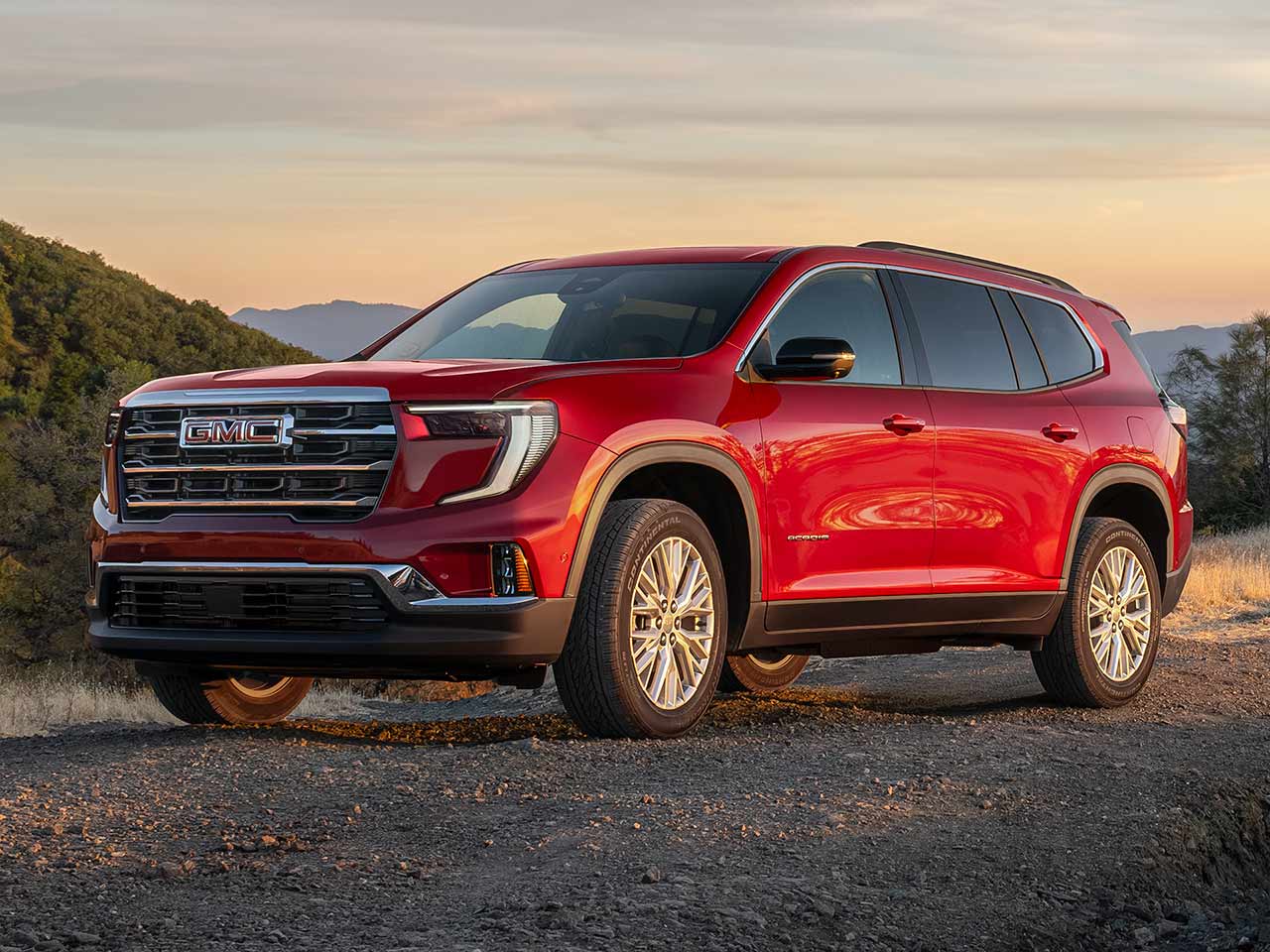 Exterior Front Three-Quarters View of the 2026 GMC Acadia Mid-Size SUV Driving Down the Road