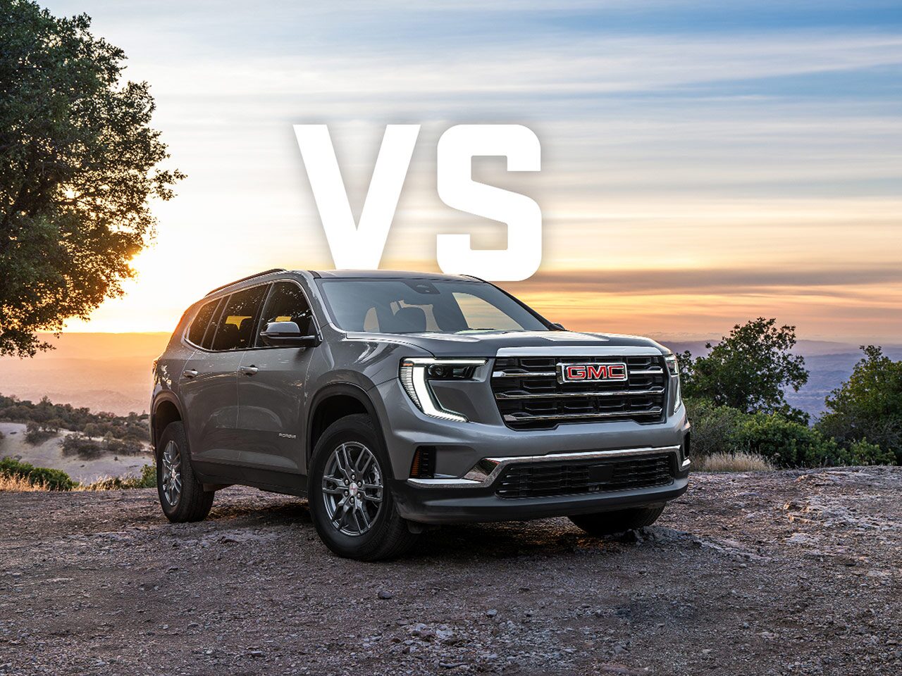 Front Three-Quarters View of the GMC Acadia Parked On a Hillside With A Sunset In the Distance