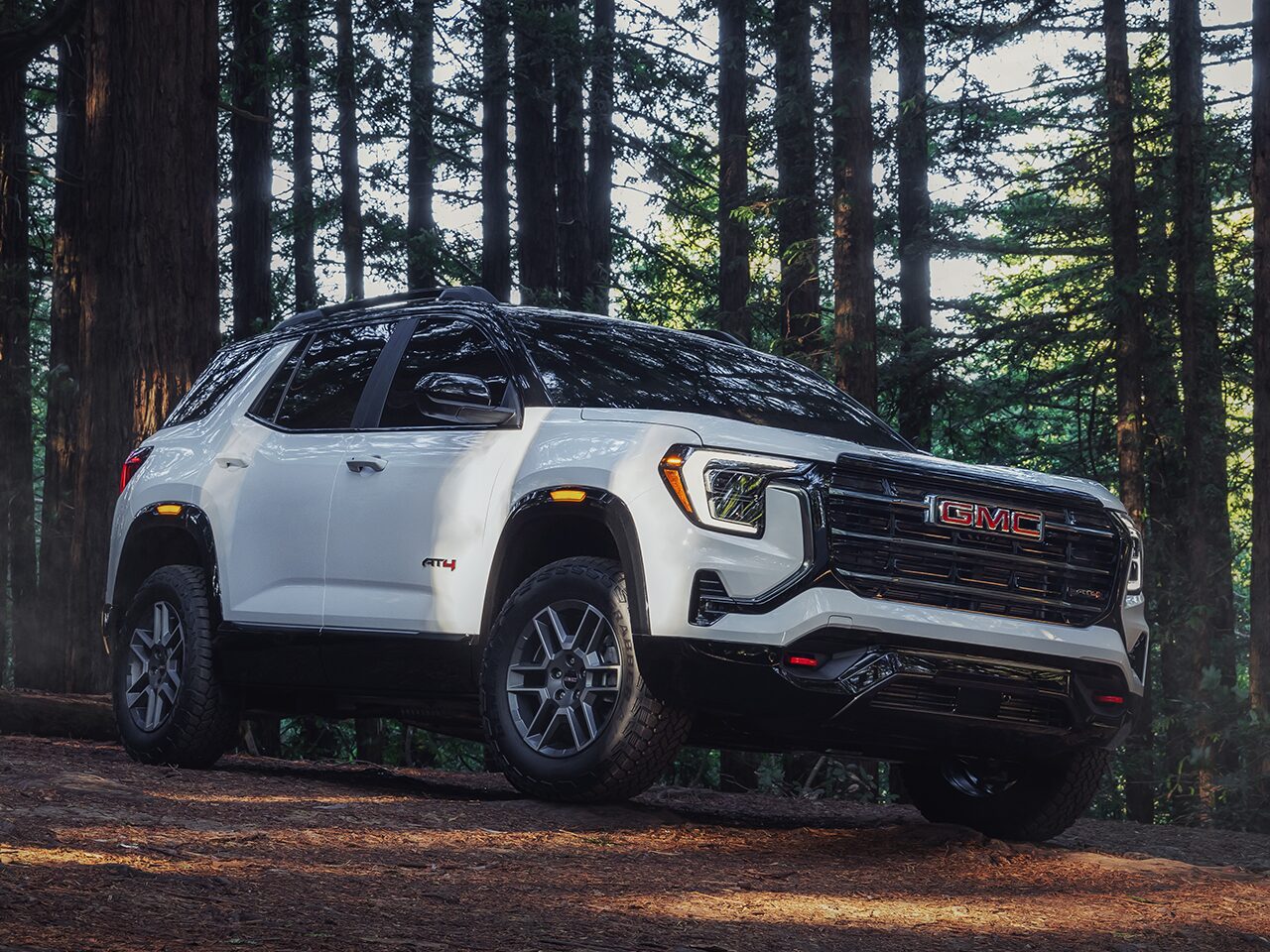 Front Three-Quarter View of the 2026 GMC Terrain AT4 Small Off-Road SUV Driving Through the Forest