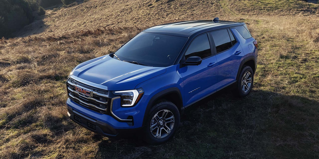Birds-eye View of a Blue 2026 GMC Terrain Elevation Compact SUV Parked in a Grassy Field