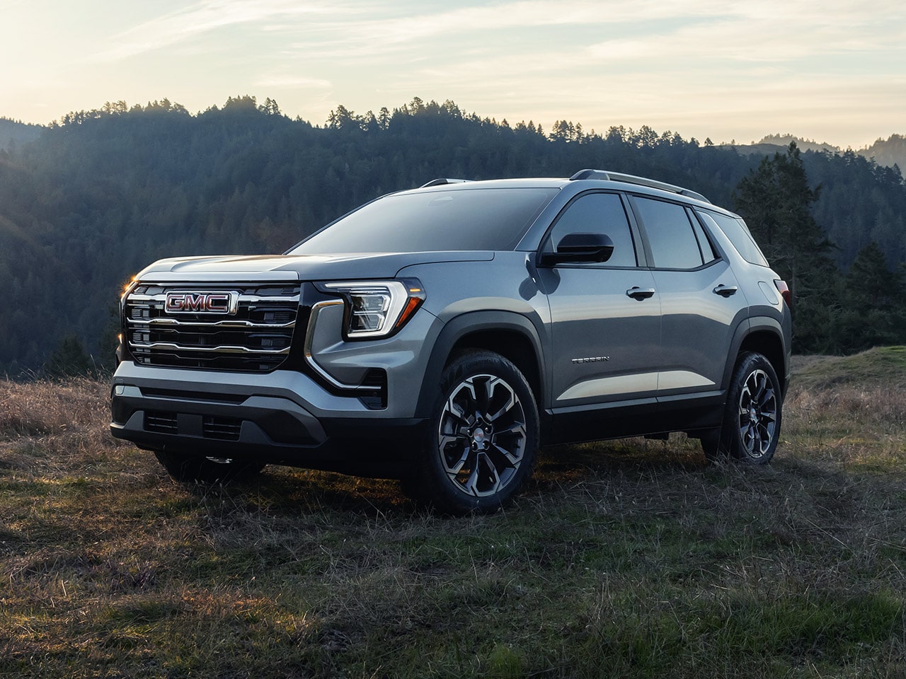 Front Three-Quarter View of the 2026 GMC Terrain Elevation Compact SUV Parked on a Hill Top at Sunrise
