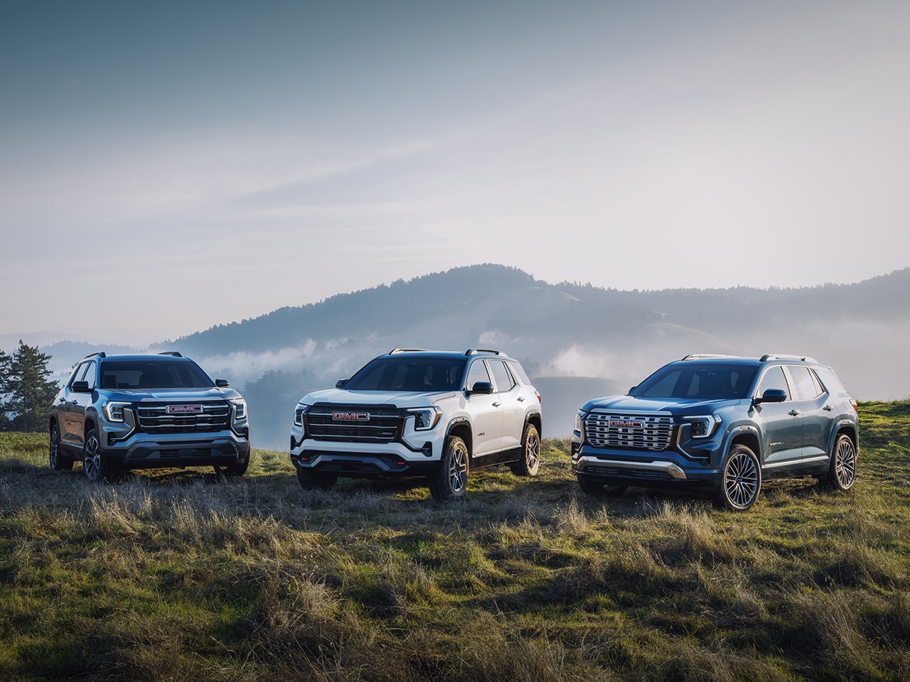 The 2026 GMC Terrain Small SUV Lineup Parked in a Valley Over Looking a Beautiful Mountain Range