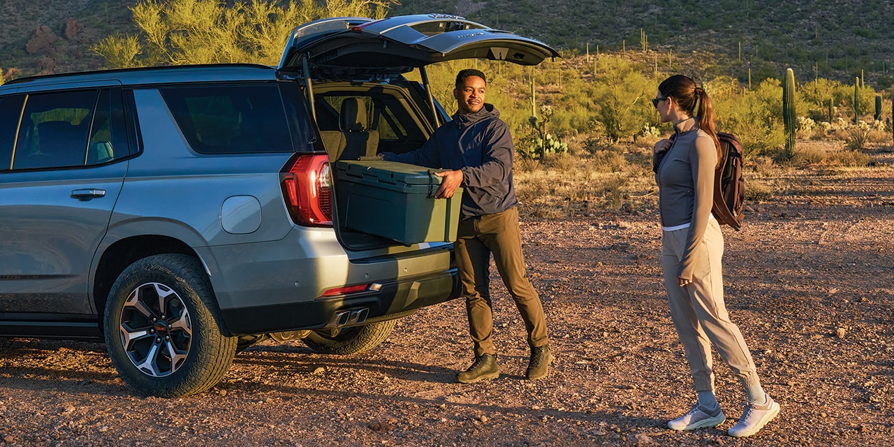 A Man Using the Autosense Power Liftgate While Loading the Cargo Space of his 2026 GMC Yukon AT4