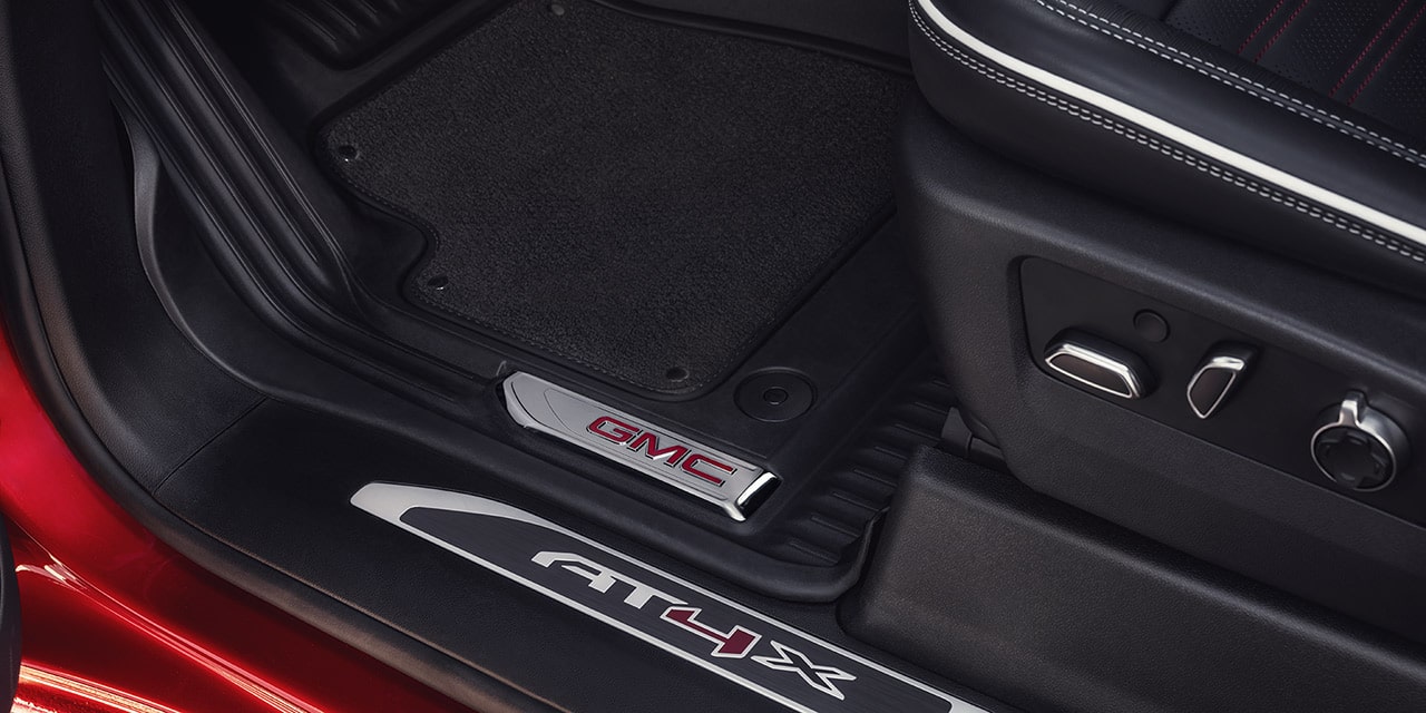 Close-up View of the Seat Controls and "AT4X" Branded Kickplate in a 2026 GMC Sierra HD AT4 Truck