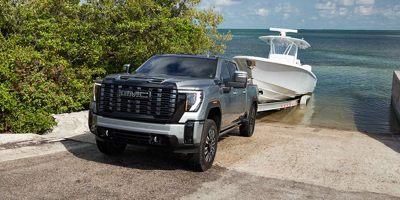 Three-Quarter View of a 2026 GMC Sierra HD Denali on the Boat Ramp Hauling a Boat Out of the Lake
